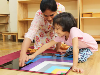 A Montessori teacher playing with a child – preprimary program – Mont Ivy Preschools
