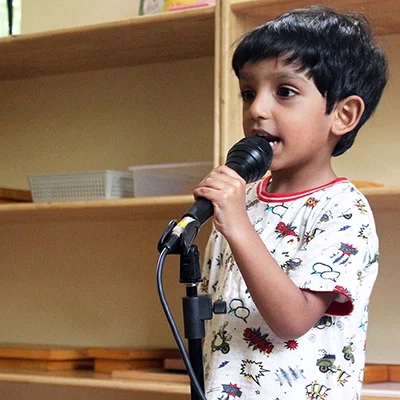 A young boy standing in front of a microphone – Mont Ivy Preschools