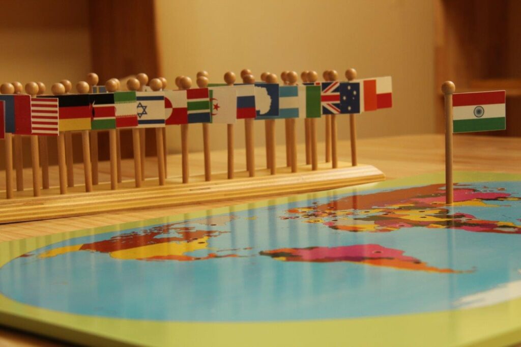 a world map with flags on top of it  – Mont Ivy Preschools
