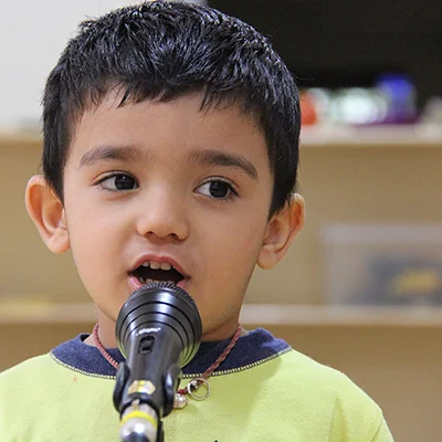 a young boy holding a microphone near his mouth – Mont Ivy Preschools