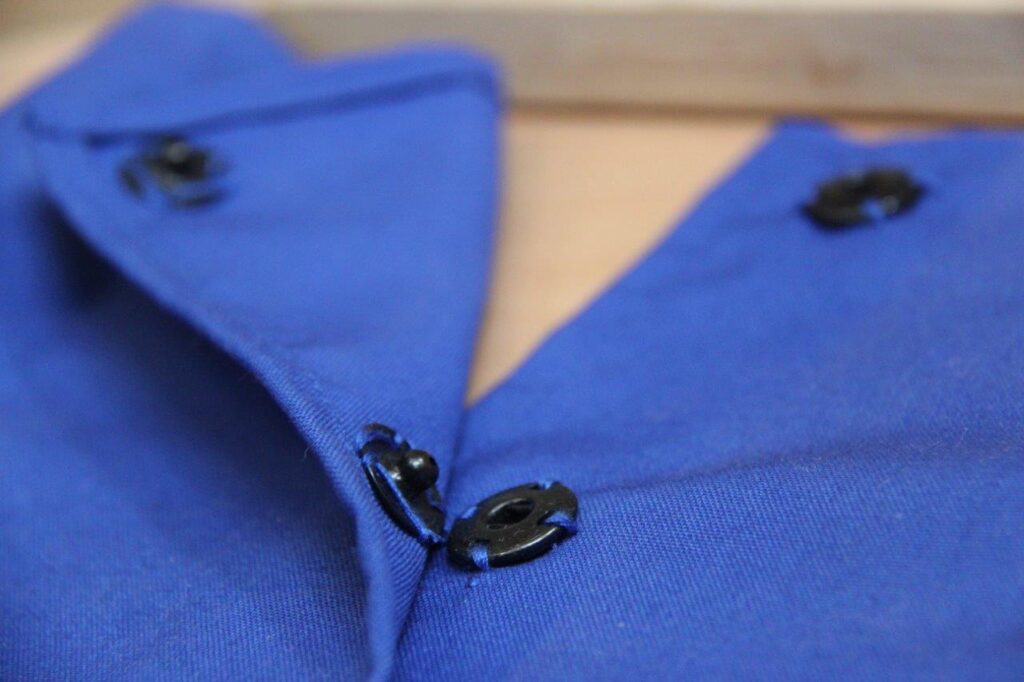 a close-up of a blue shirt with black buttons - press-studs frame – Mont Ivy Preschools